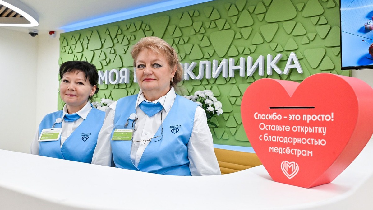 Администраторы детской городской поликлиники № 30 Юлия Афанасьева и Надежда Шевлякова встречают первых пациентов — здание открылось после масштабной реконструкции по новому московскому стандарту