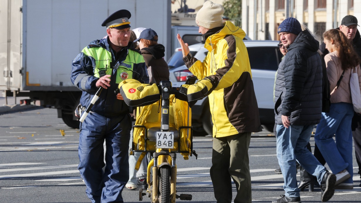 Инспектор ГИБДД и велокурьер во время профилактического рейда среди электросамокатчиков и велосипедистов
