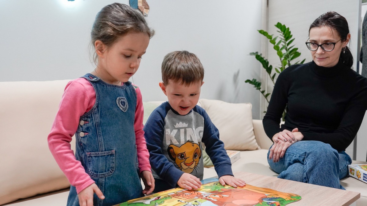 Воспитанники Центра содействия семейному воспитанию имени Ю. В. Никулина Марина и Тимофей изучают детскую развивающую игру вместе с воспитателем Мариной Ефимцевой. В центре создаются все условия для комфортного пребывания детей и их социализации