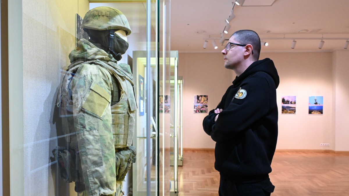 Заместитель заведующего экспозиционно-выставочным отделом Государственного центрального музея современной истории России Иван Агафонов рассматривает военную форму, принадлежавшую бойцу с позывным «Ворчун»