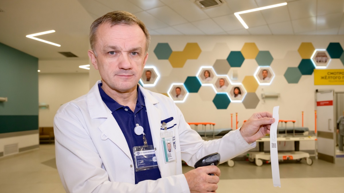 Главный врач Городской клинической больницы № 15 им. О. М. Филатова Валерий Вечорко сканирует браслет с QR-кодом, который выдают пациентам при поступлении. Новая система идентификации упростила работу медиков