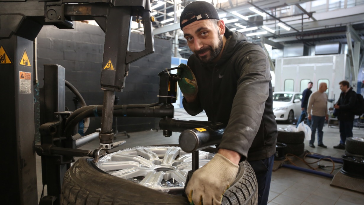 Механик Герасим Григорян на станции шиномонтажа у метро «Окружная» за работой