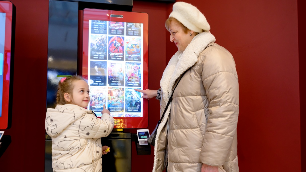 Москвичка Анна Миронова с внучкой Екатериной Красоткиной покупают билеты на показ фильма в кинотеатре «Рассвет»
