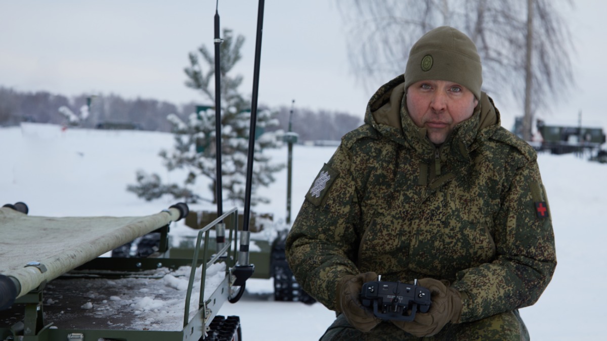 Командир медицинского взвода 22-го мотострелкового полка группировки «Север» с позывным «Цыган» показывает наземный роботизированный комплекс, который помогает эвакуировать раненых