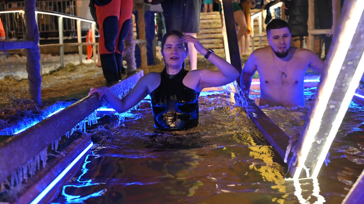 Москвичка Вера Ковалева, участница крещенских купаний, входит в купель с освященной водой, которую оборудовали у храма Живоначальной Троицы в Останкине на Останкинском пруду