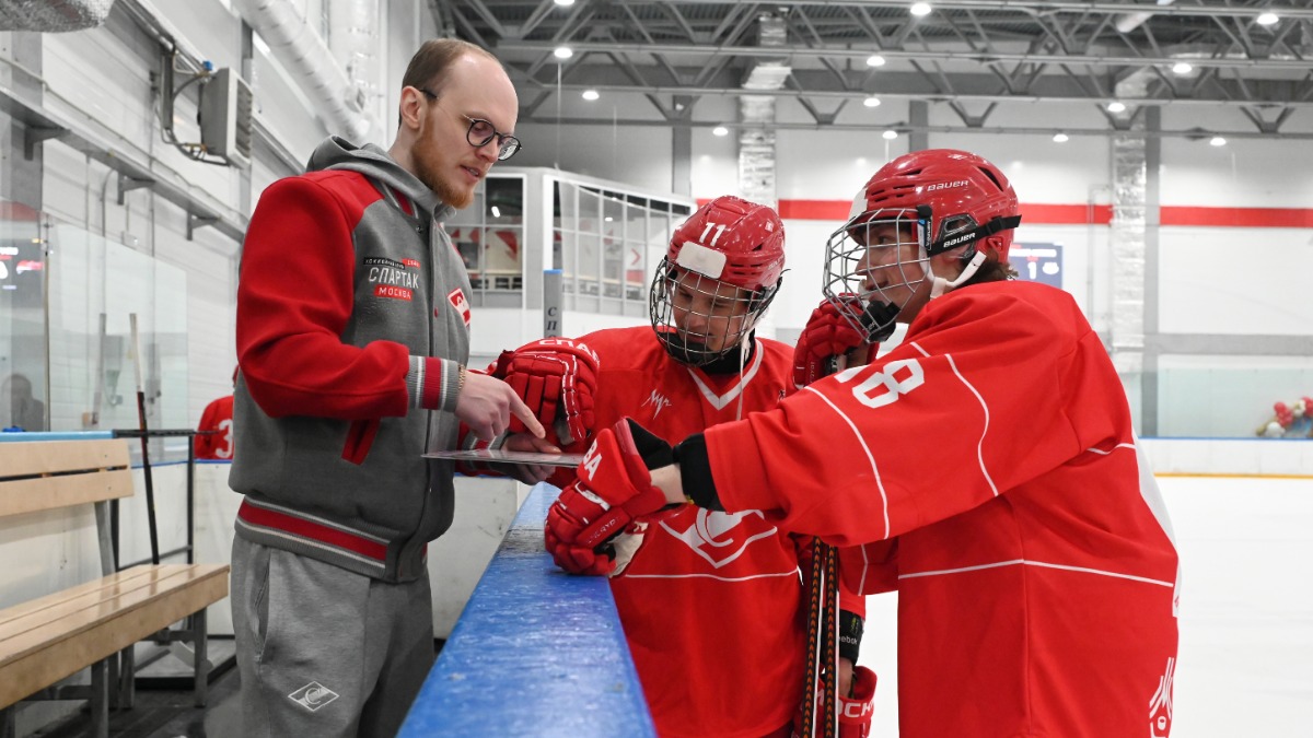 Тренер хоккейной академии «Спартак» Святослав Акимов обсуждает тактику с хоккеистами-юниорами, братьями Денисом и Данилом Анисимовыми, в матче с «Гранит-Митино»
