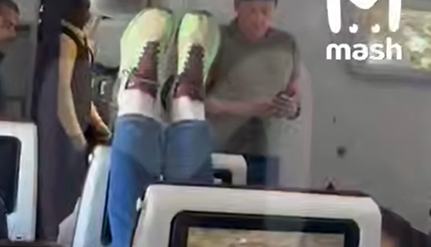 Пассажирка самолета закинула ноги на подголовник сидящего спереди человека