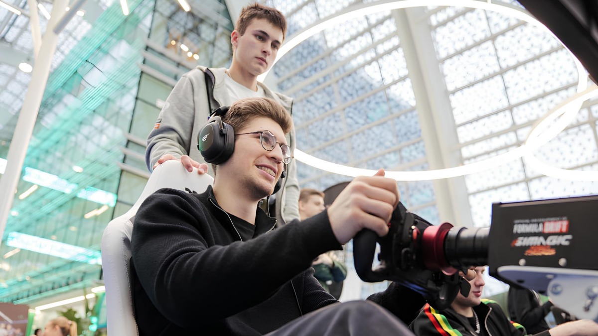 Представитель одной из компаний-разработчиков Виталий Степанов и участник мероприятия Александр Швецов на Московской неделе видеоигр. Александр тестирует видеоигру, а представитель компании ориентирует его по управлению