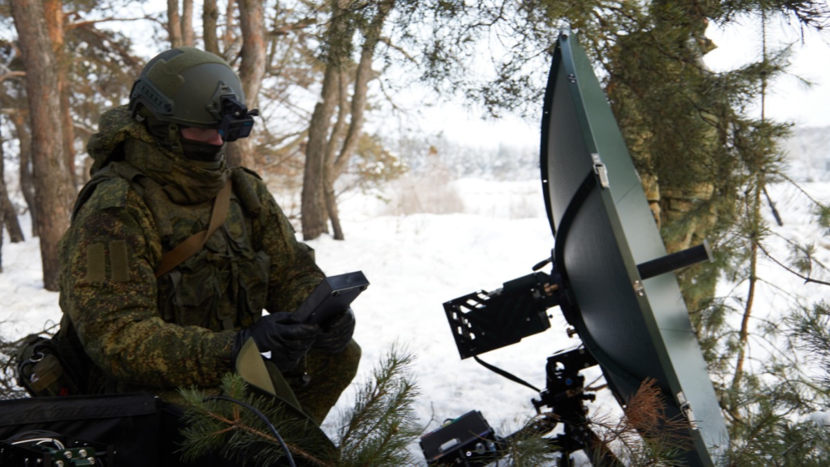 Боец группировки войск «Север» настраивает спутниковую связь в зоне СВО