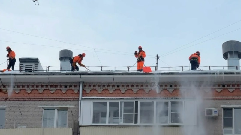 Столичные специалисты проводят очистку крыш жилых домов после снегопада
