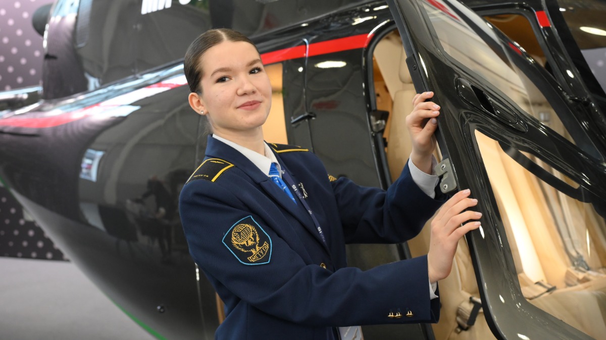 Первокурсница Московского государственного технического университета гражданской авиации Екатерина Степина осматривает кабину обновленного легкого вертолета Ми-34М1 с новейшим отечественным двигателем