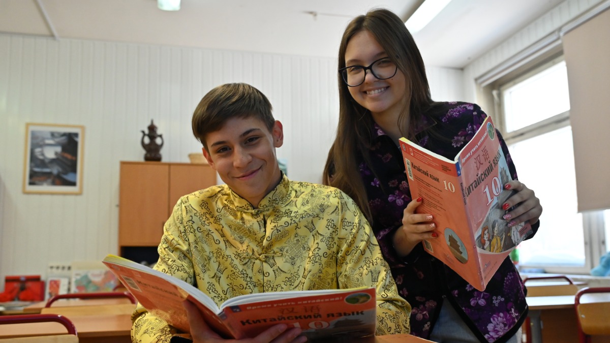 Ученики 10-го класса школы № 1948 Владимир Фомин и Александра Костоправкина с учебниками китайского языка, который они учат со второго класса