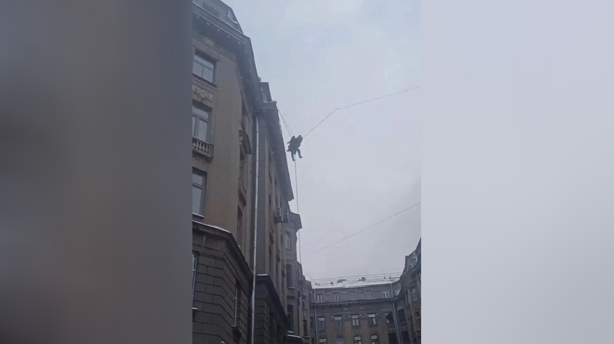 В Петербурге спустили дворника, который сорвался с крыши и повис на проводах