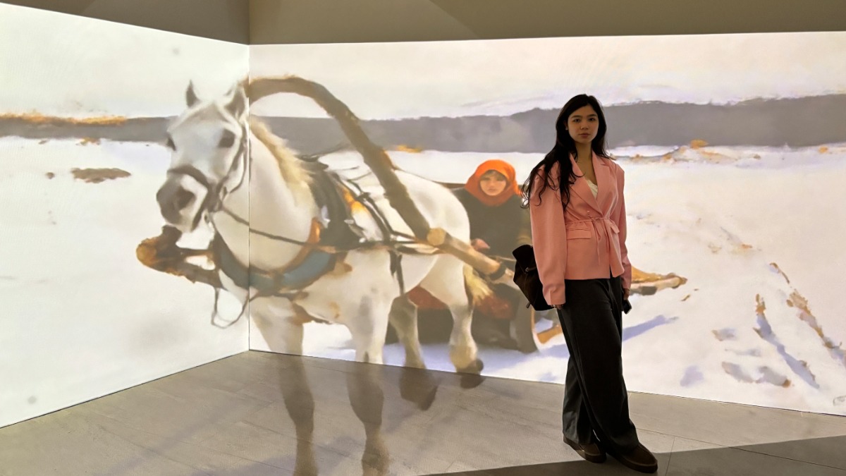 Посетительница выставки «Импрессионизм с русской душой» Амина Тугушева позирует на фоне объемной проекции. Дизайнерское решение привлекло много моделей