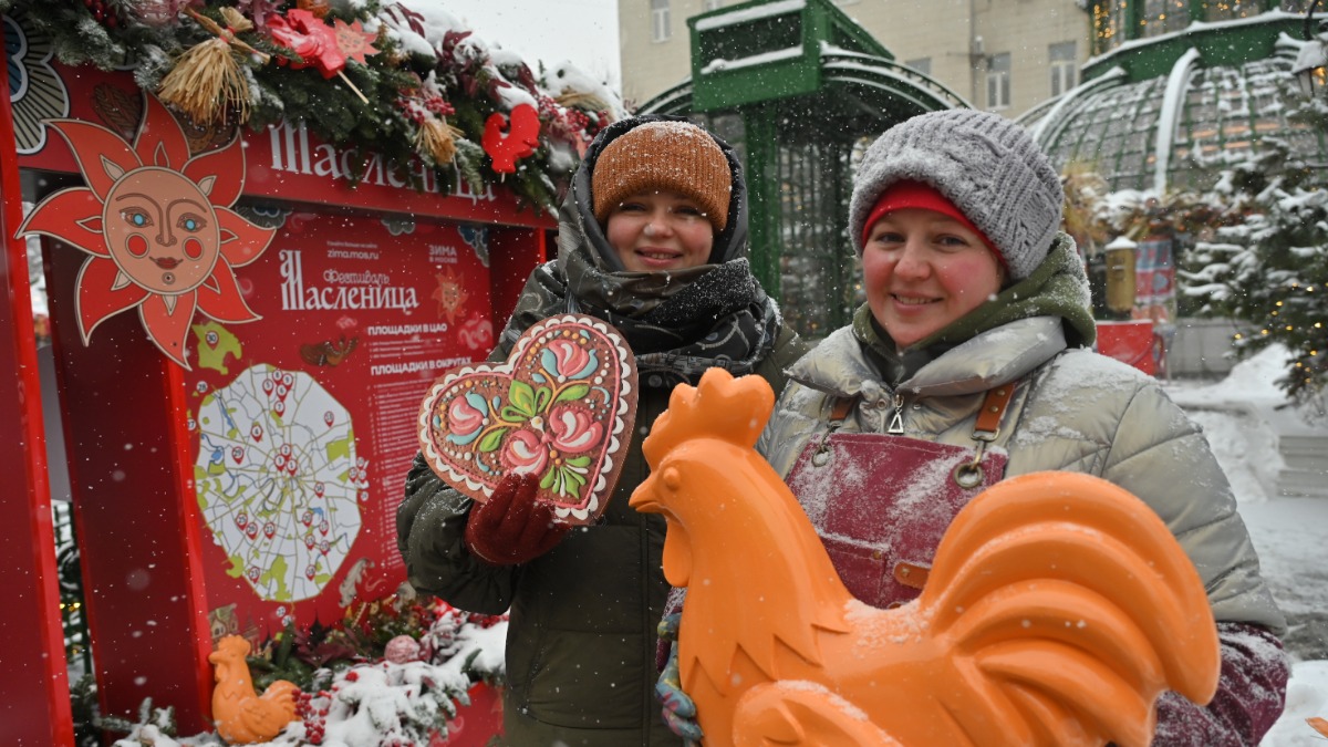 Декораторы Дарья Олейникова и Екатерина Романова демонстрируют элементы украшений на фестивальной локации на Тверской площади. Большие петушки, символы солнца и расписных сердец стали частью масленичного декора