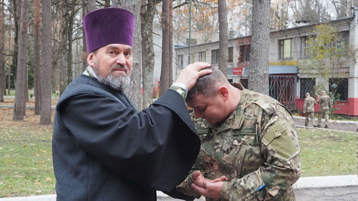 Командир взвода добровольческого отряда «БАРС-Брянск» и батальонный священник Александр Беликов благословляет одного из военнослужащих перед очередным боевым заданием