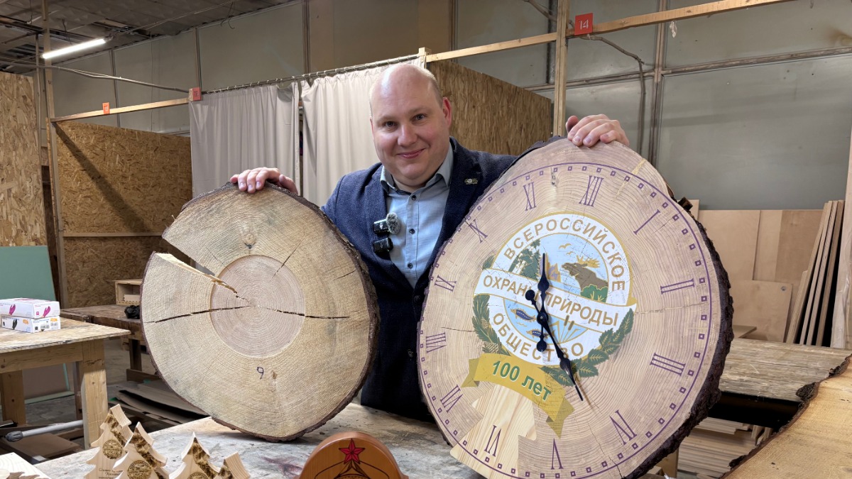 Исполнительный директор Московского областного отделения Всероссийского общества охраны природы Ярослав Вольпин показывает сувенир в виде настенных часов, которые сделали из Кремлевской новогодней ели