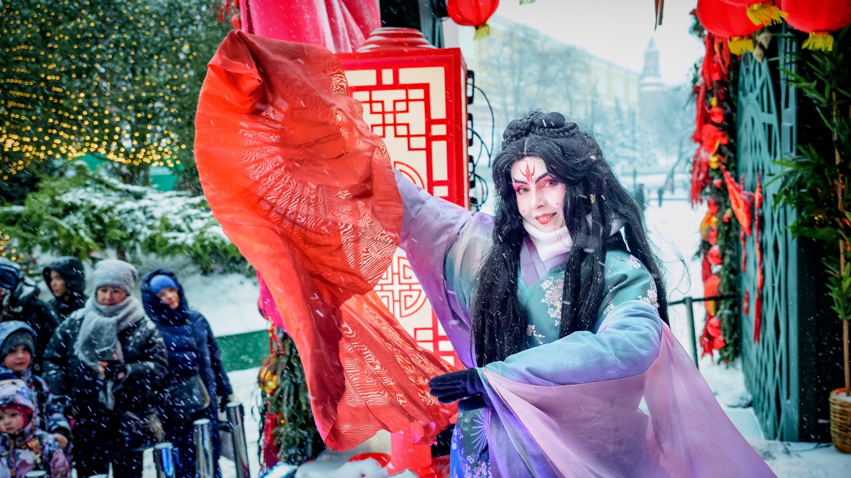 Актриса «Московских сезонов» Марина Засухина выступает на Манежной площади и предлагает гостям сфотографироваться в китайских декорациях