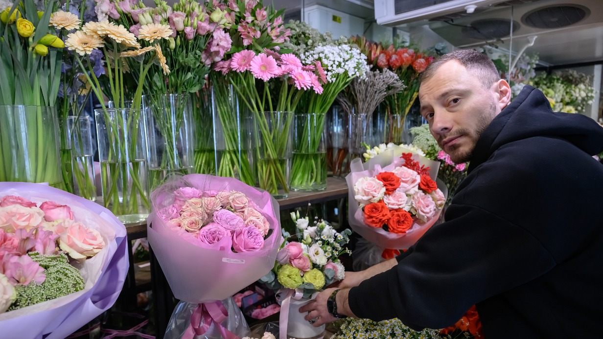 Флорист Виктор Соловов в салоне цветов на Ярцевской улице подбирает для клиента букет