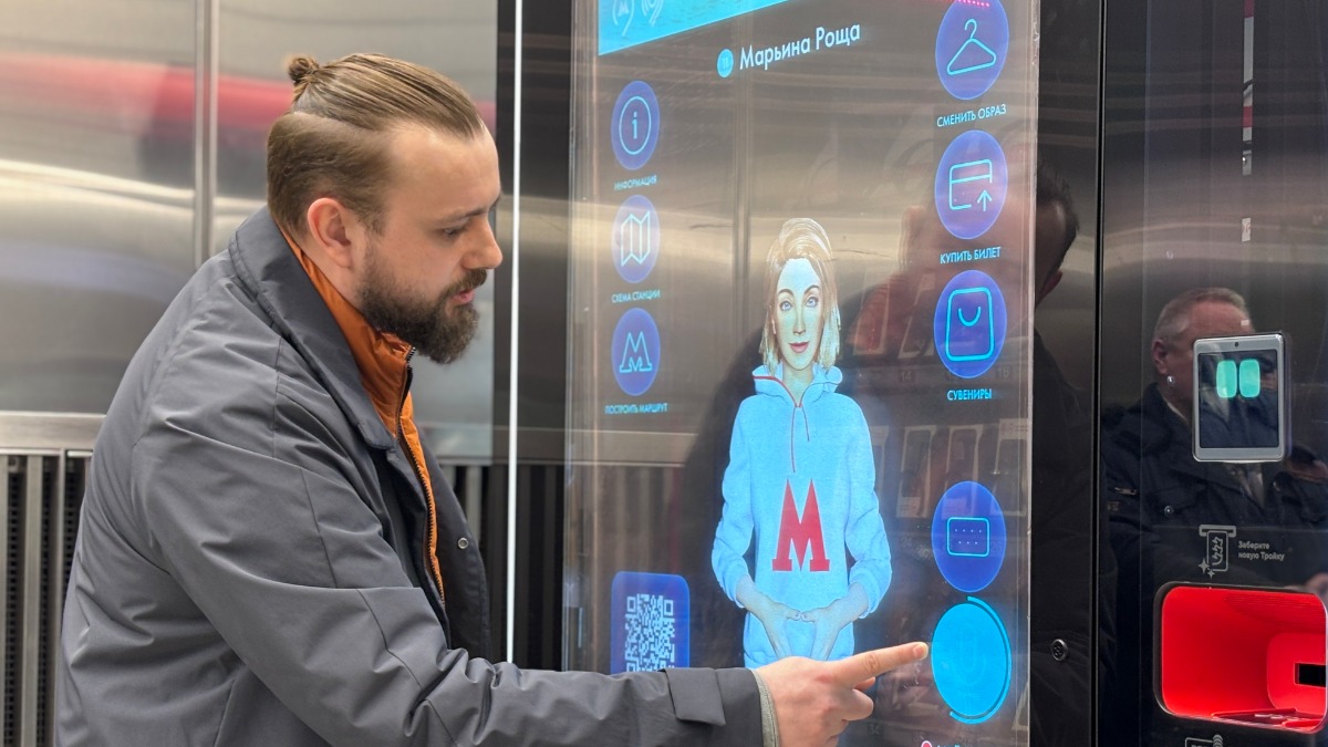 Начальник навигационно-информационного комплекса метро Сергей Литвинович демонстрирует работу и возможности Александры на цифровой стойке общения на станции «Марьина Роща»