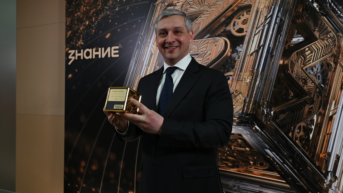 Лауреат награды «Знание.Премия», и.о. директора Института изучения детства, семьи и воспитания Александр Цветков держит в руках статуэтку, врученную его команде за просветительский проект «Разговоры о важном»