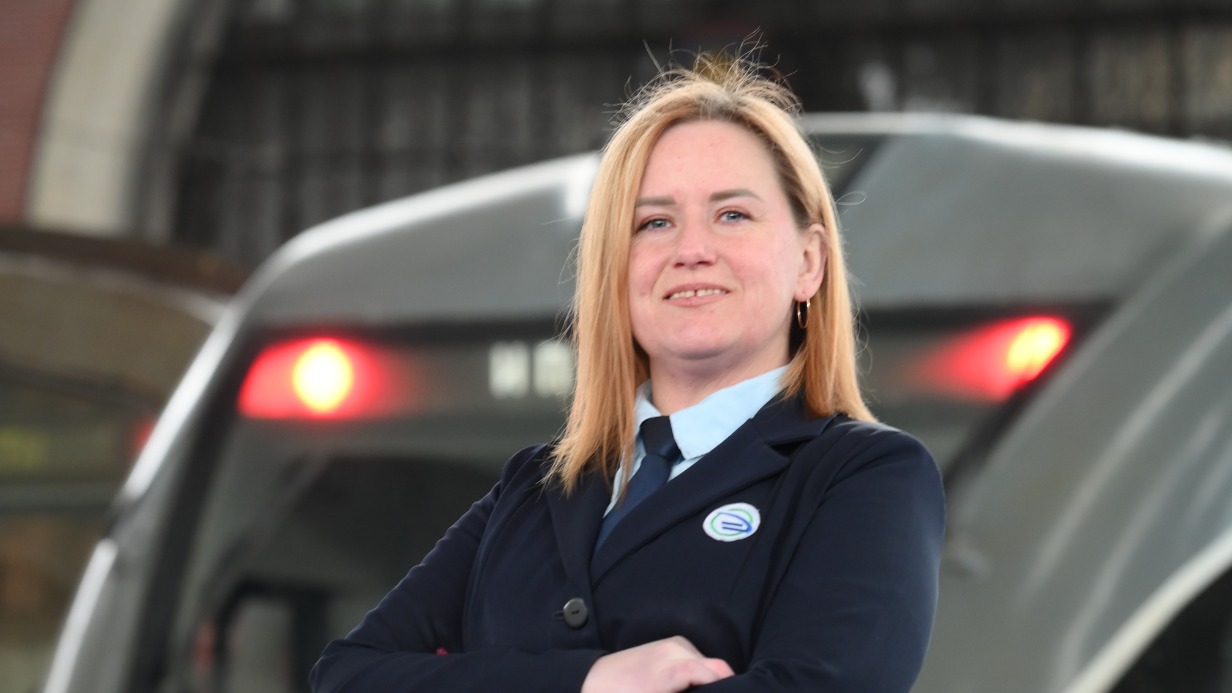 Москвичка Ольга Макарова на фоне электропоезда. Она работает помощником машиниста уже два года