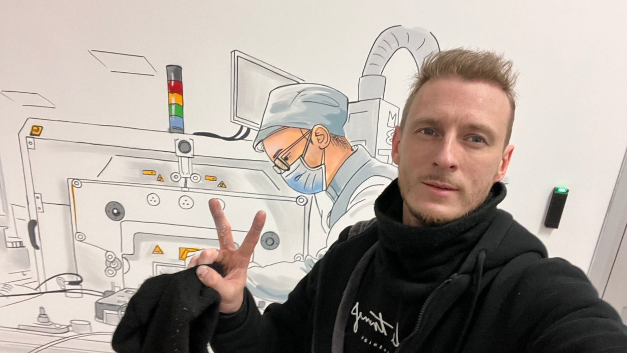 Художник Алексей Бевзенко на фоне своих работ на площадке особой экономической зоны