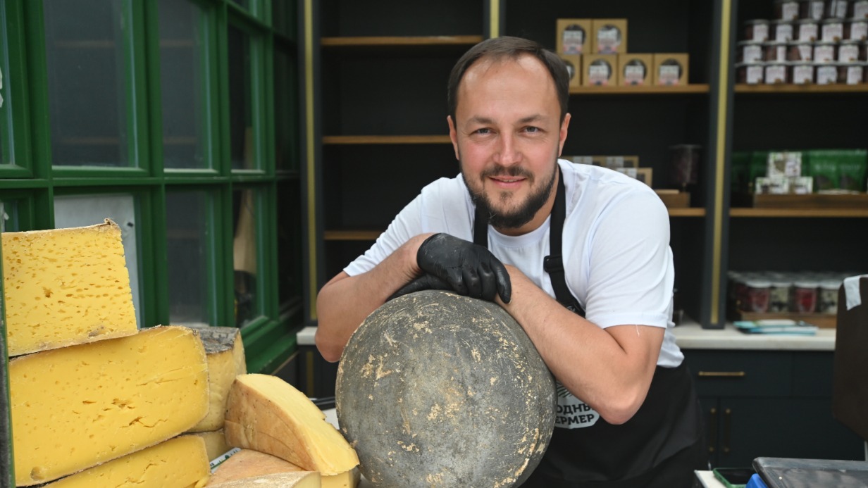 Сыровар Александр Волков показывает товар на ярмарке на Тверской площади