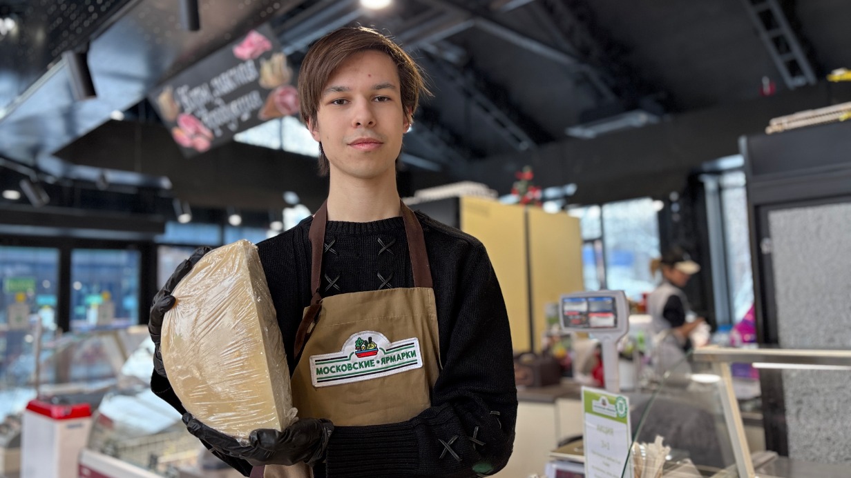 Продавец Марк Осин показывает один из крафтовых сортов сыра