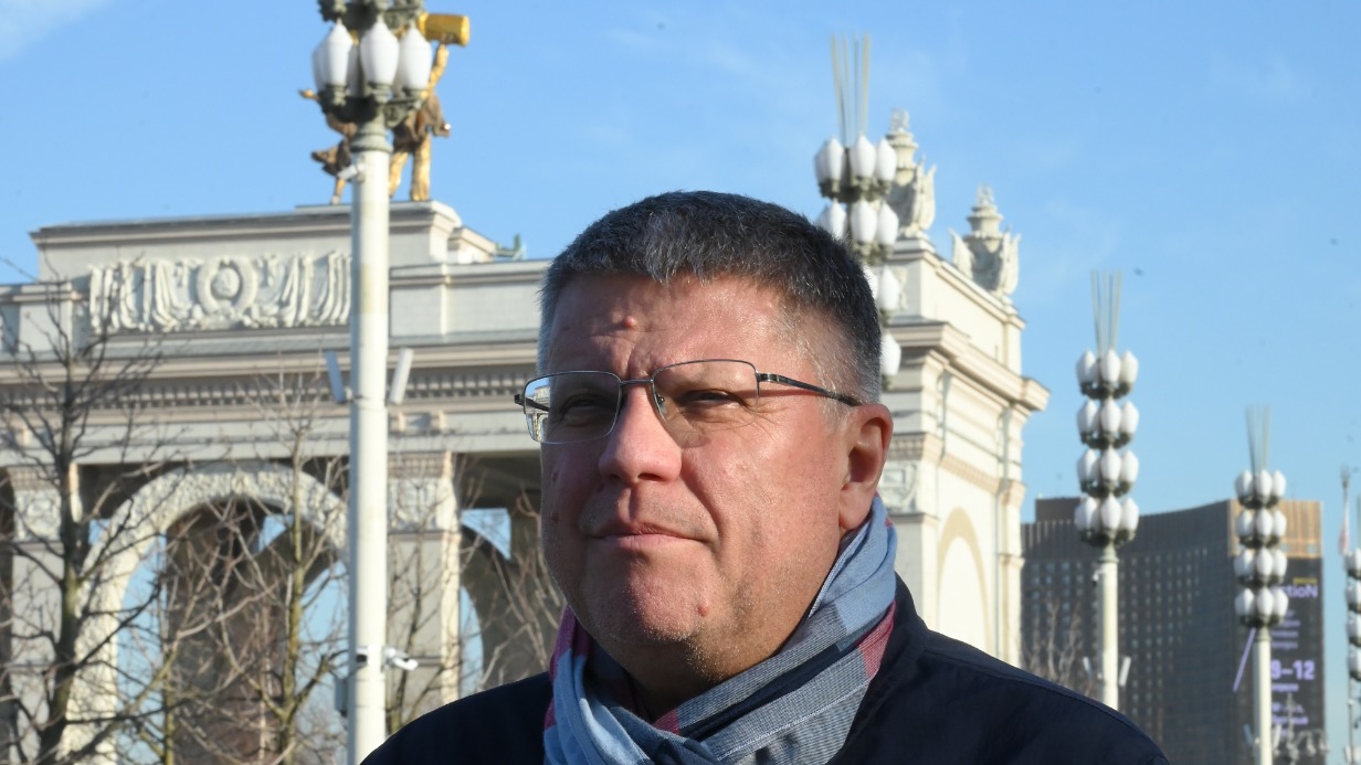 Историк Павел Нефедов на фоне плафонов «Колос» на ВДНХ