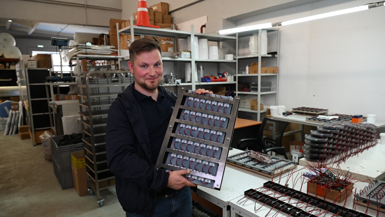 Директор по развитию компании Кирилл Санаев показывает дорожный знак с уже установленными светодиодами