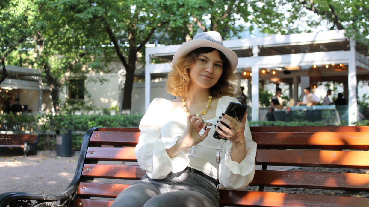 Москвичка Кира Лунная с мобильным телефоном в Парке Горького