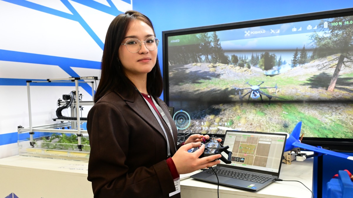 Инженер-методист компании-разработчика дрона Татьяна Обыденко на выставке Московского международного Салона образования показывает, как школьники могут использовать симулятор дрона