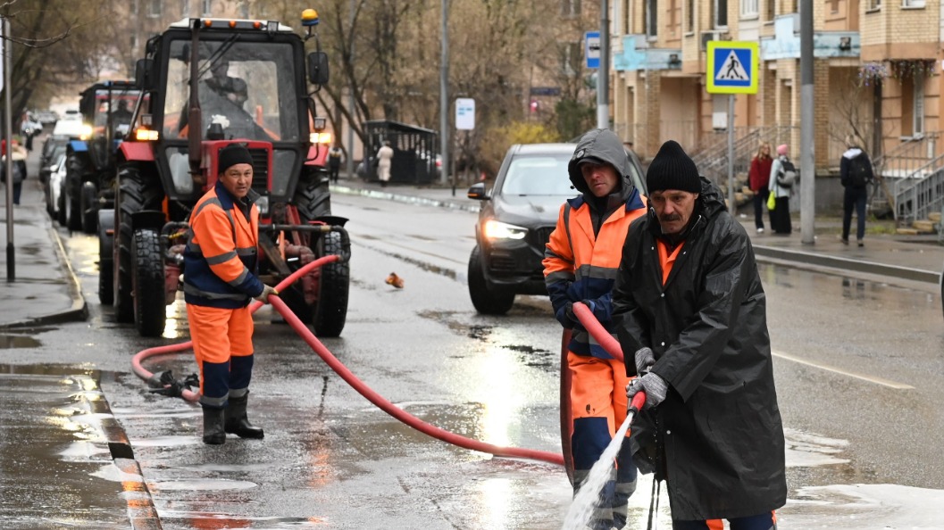 Рабочие Гафур Саманов, Владимир Хрулев и Алексей Шаманов промывают дорогу у дома № 36 на 4-й Гражданской улице