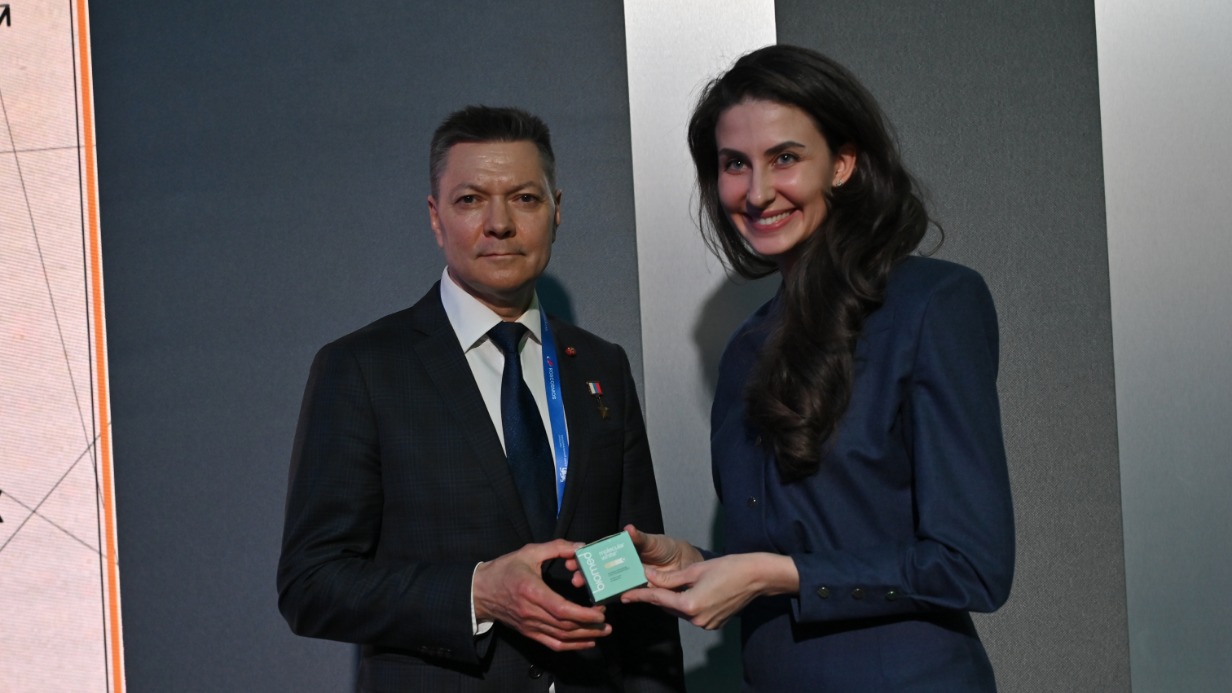 Бренд-директор компании — производителя зубной пасты в таблетках Анастасия Нидзий передает новый продукт космонавту Олегу Кононенко