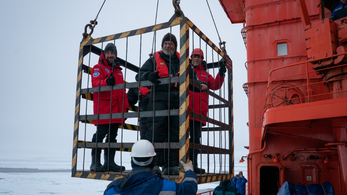 Научные туристы наблюдают с палубы ледокола за процессом высадки на полярные льды путешественника Федора Конюхова и его команды