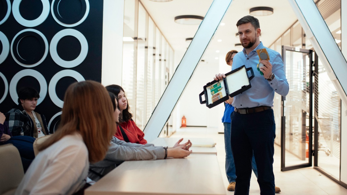 Один из разработчиков спутника, заместитель директора Института радиотехники и информатики РТУ МИРЭА Святослав Литвинов показывает студентам детали, используемые в аппарате