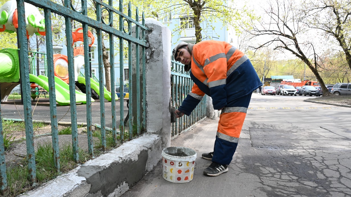 Сотрудник ГБУ «Жилищник района Южнопортовый» штукатур Асламбек Акбаров восстанавливает покрытие опор забора на улице Трофимова