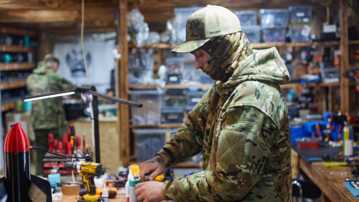 Военнослужащий 82-го мотострелкового полка группировки ВС РФ «Север» с позывным «Дэйл» трудится в мастерской, подготавливая дрон к боевой работе