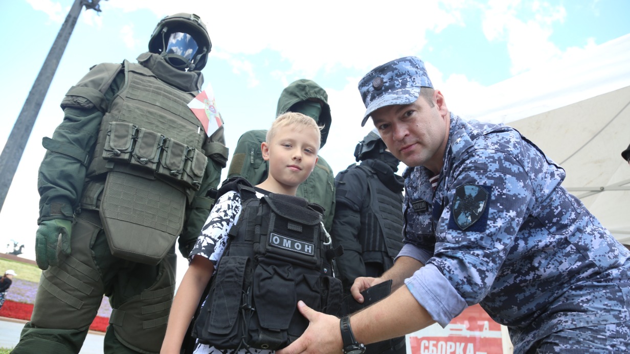 Старший инженер отдела боевого обеспечения, майор Виталий Кожемякин на мероприятии «Один день с Росгвардией» на Поклонной горе помог 8-летнему Егору Батаеву примерить на себя роль сотрудника — надел на него бронежилет