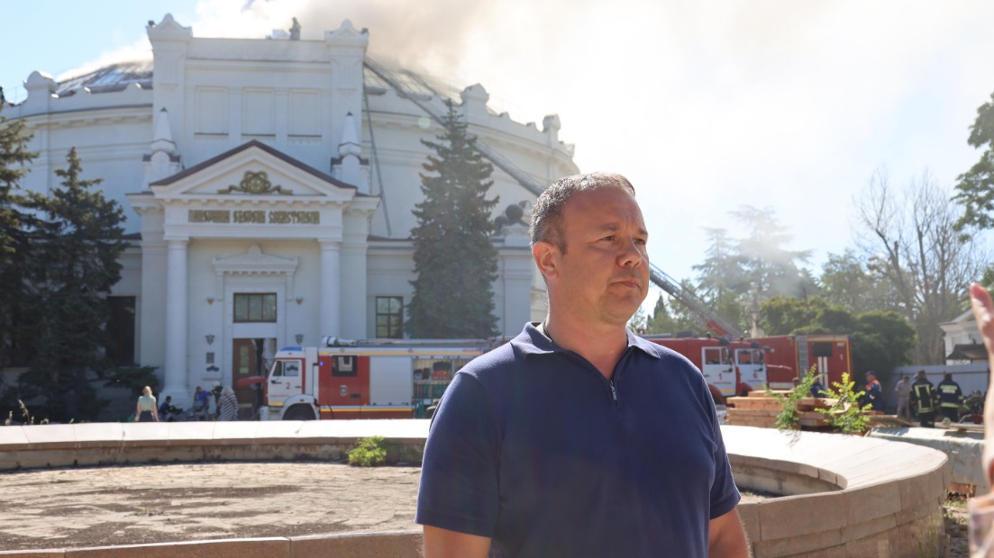Директор Музея обороны Севастополя Михаил Смородкин на фоне здания панорамы «Оборона Севастополя 1854–1855 годов», где спасатели ликвидируют пожар, возникший в результате удара беспилотника