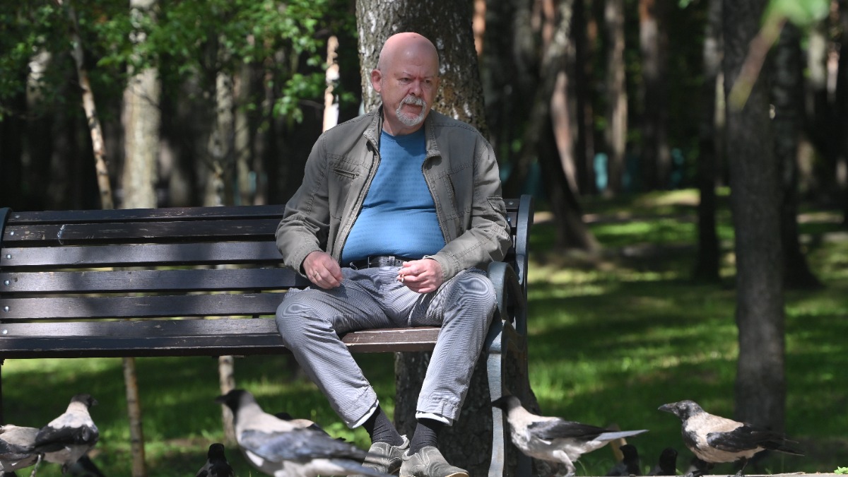 Юрий Школьник кормит ворон на лавочке в парке «Сосенки»