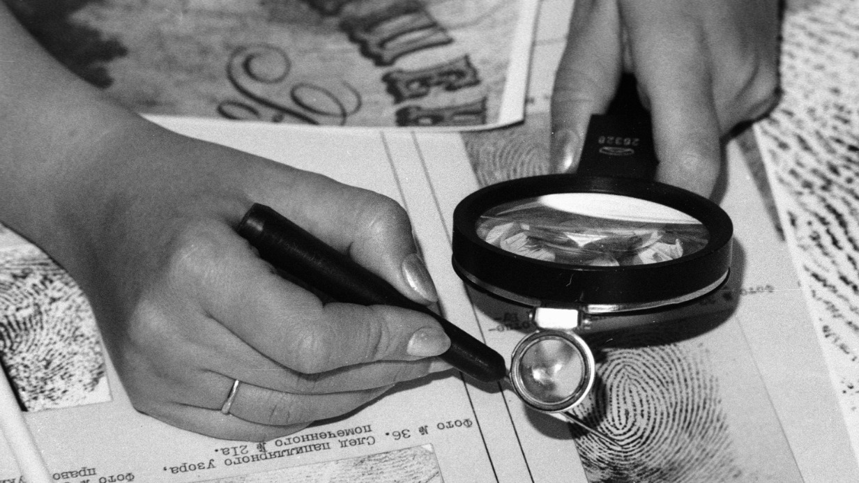 Сотрудница института судебных экспертиз рассматривает отпечатки пальцев. Фото 1989 года.