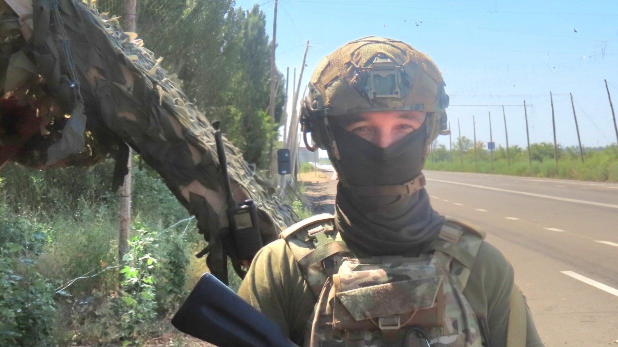 Начальник комендантского поста группировки войск «Днепр» сержант с позывным «Вжик» стоит в дозоре около «антидронового коридора» — участка шоссе, закрытого от беспилотников сетью