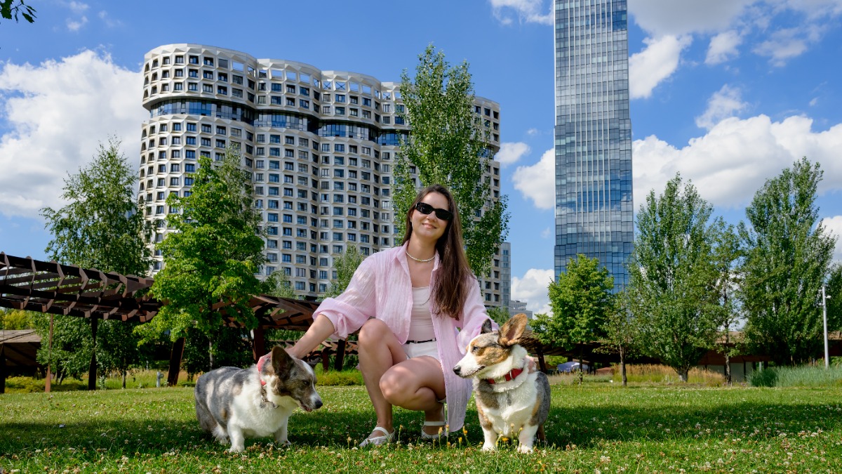  Москвичка Евгения Щегулина с корги по кличке Сырник и Круассан на лужайке жилого квартала, выросшего на месте бывшей промзоны ЗИЛ