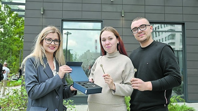 Сотрудница компании Дарья Климова вручает ключи от квартиры супругам Дарье и Федору Кургановым