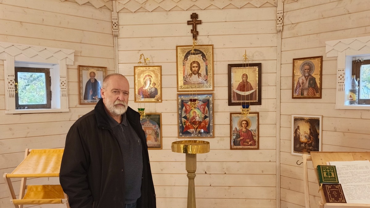 Дмитрий Зыков внутри часовни. Подставка под свечи тоже сделана его руками