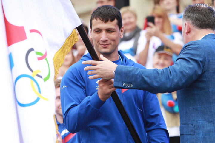 Семикратный чемпион мира по самбо Артем Осипенко получает знамя сборной страны из рук президента Олимпийского комитета России Станислава Позднякова