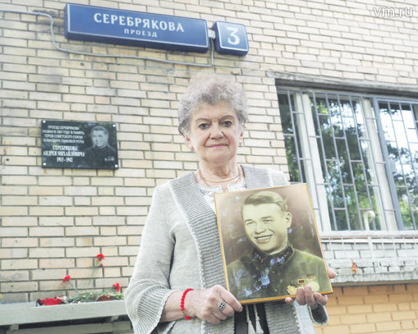 Людмила Серебрякова с портретом своего отца, танкиста Андрея Серебрякова, на улице, носящей его имя